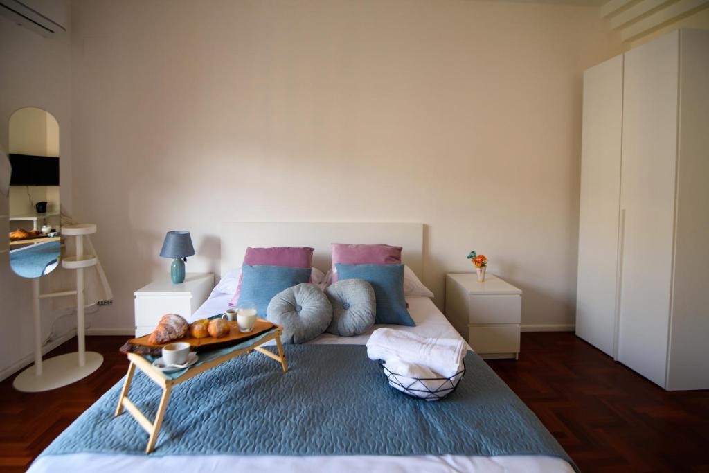 a bedroom with a bed with blue and pink pillows at Sallù Boutique in Salerno
