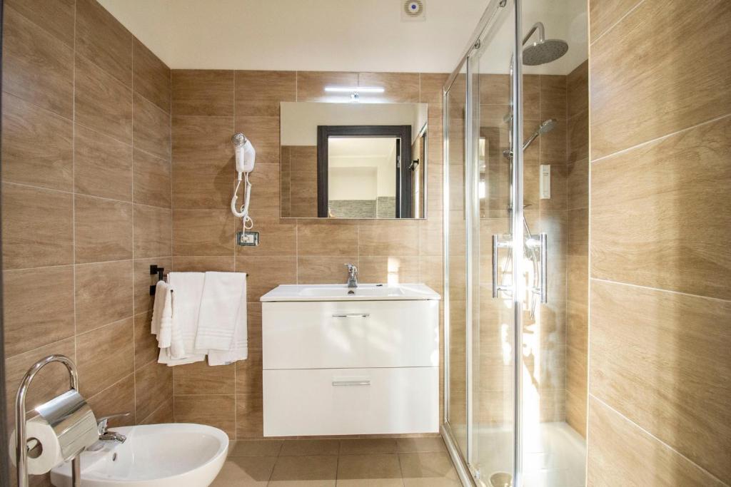 a bathroom with a toilet and a sink and a shower at Royal Playa Suite and Apartament -private parking- self chek out in Catania