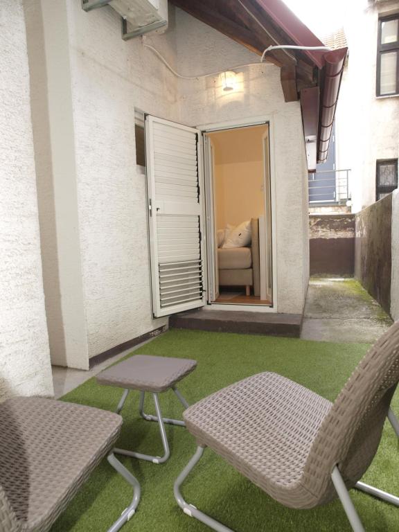 patio z 2 krzesłami, stołem i kanapą w obiekcie Cozy Studio Apartment Tian in Zagreb w Zagrzebiu