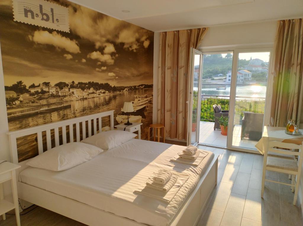 1 dormitorio con 1 cama con una pintura en la pared en Villa Nobilo, en Lumbarda