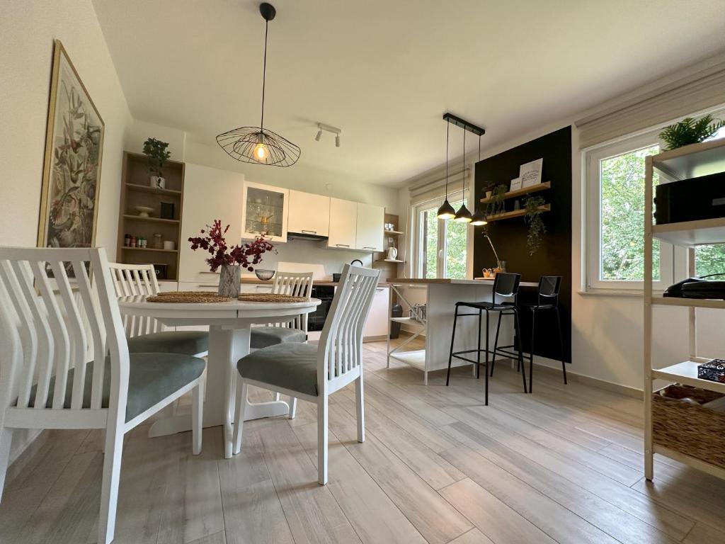 a kitchen and dining room with a table and chairs at Summer Green Apartment in Nedeščina