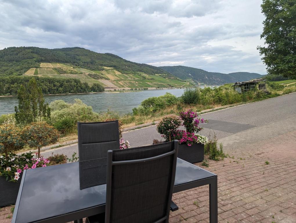 NiederheimbachにあるFerienwohnung Rheinperleの川の景色を望むテーブルと椅子