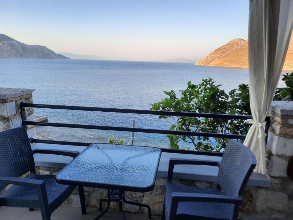 a table and chairs on a balcony overlooking the water at Margaritas apartments in Symi