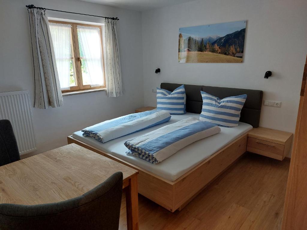 um quarto com uma cama com duas almofadas em Haus Kurparkblick Ferienwohnung Lautersee em Mittenwald