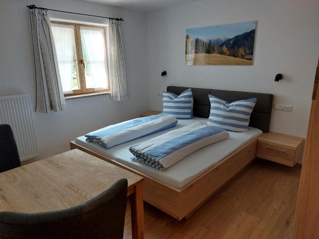 une chambre avec un lit avec deux oreillers dessus dans l'établissement Haus Kurparkblick Ferienwohnung Lautersee, à Mittenwald