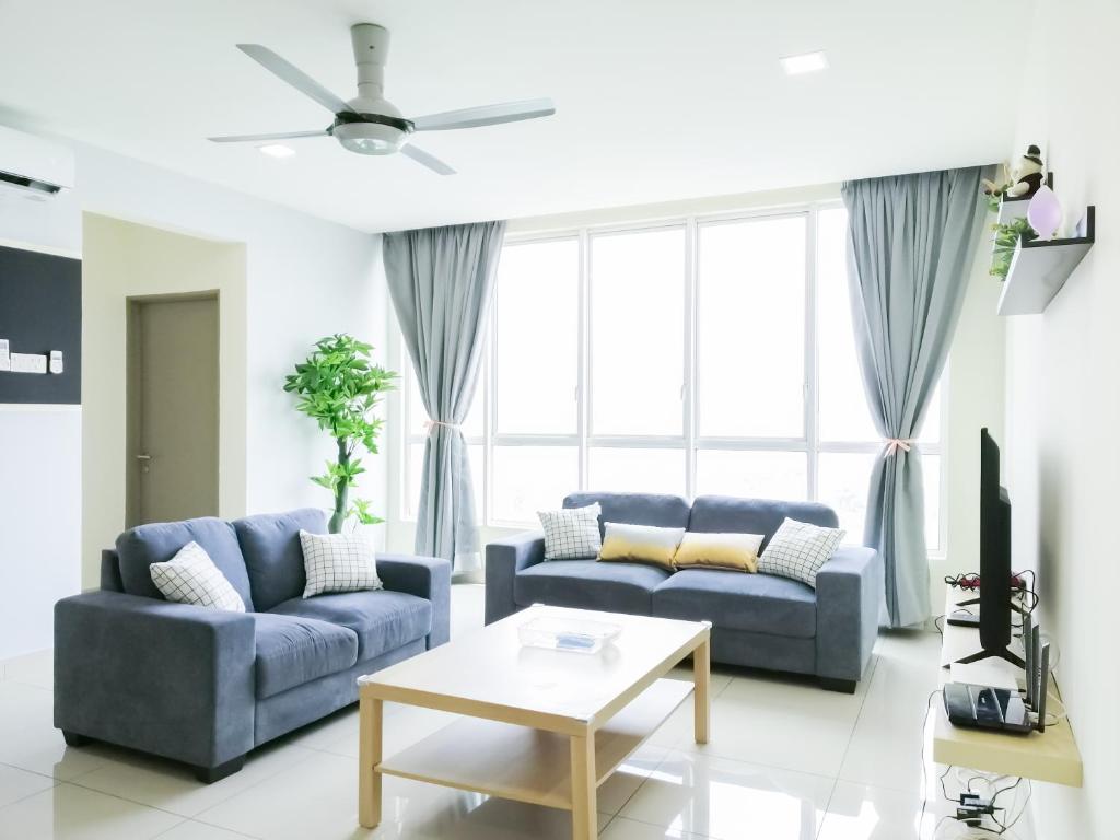 una sala de estar con 2 sofás azules y una mesa. en Setapak Central Signature Suites by Manhattan Group en Kuala Lumpur