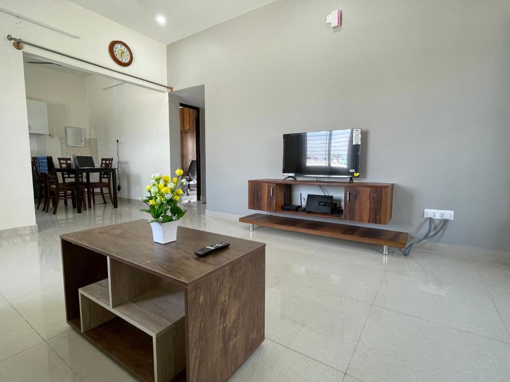 ein Wohnzimmer mit einem TV und einem Couchtisch in der Unterkunft SSN Home Stays in Bangalore near PLAY Arena in Bangalore