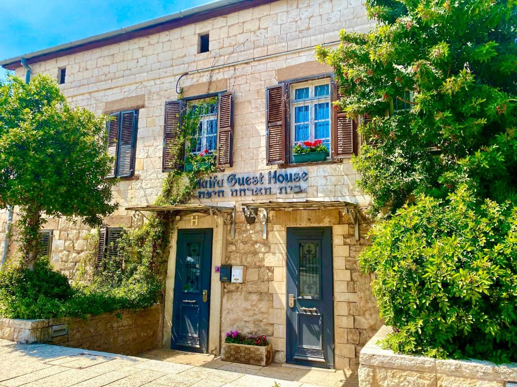 un antiguo edificio de ladrillo con un cartel para una casa de huéspedes en Haifa Guest House en Haifa