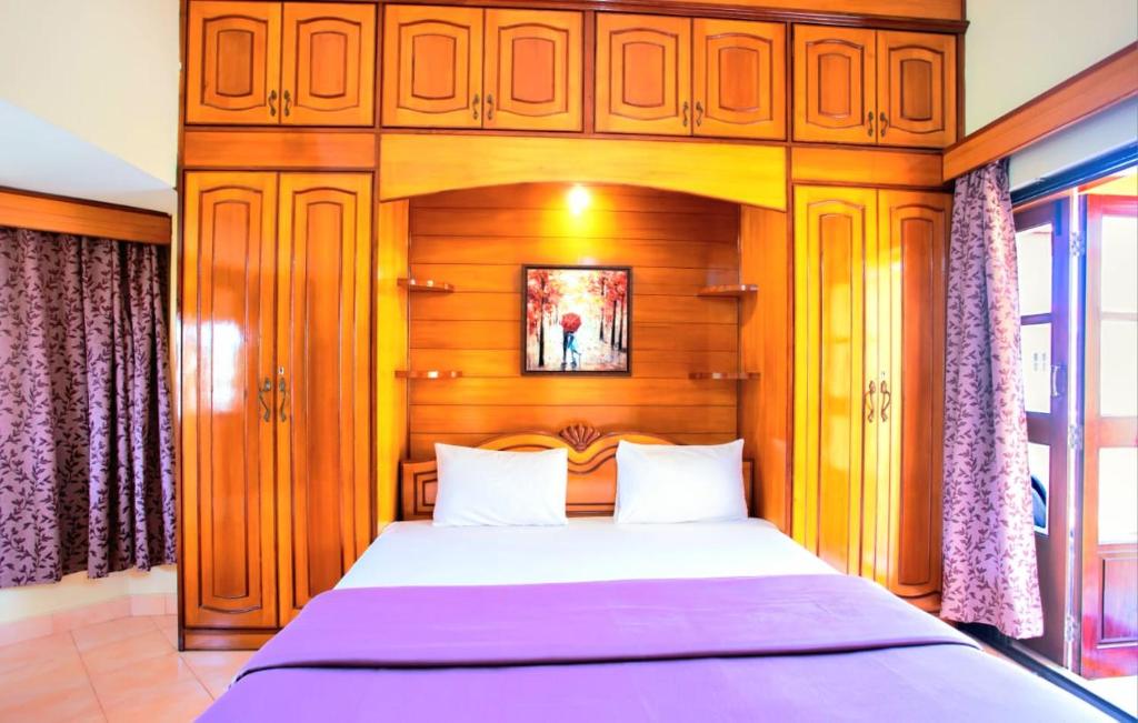a bedroom with a large bed with a wooden headboard at 'Golden Sea Breeze' Beach villa in Benaulim