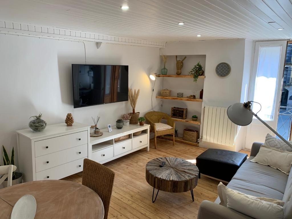 ein Wohnzimmer mit einem Sofa und einem TV in der Unterkunft APARTAMENTO CON ENCANTO TÍPICO CERETÀ Centro in Puigcerdà