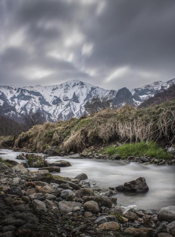 a river with snow covered mountains in the background at Maison de Varennes in Chambon-sur-Lac