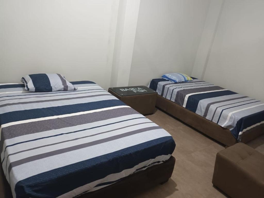 2 Einzelbetten in einem Zimmer mit Nervenkitzel in der Unterkunft Firenze House Iquitos in Iquitos