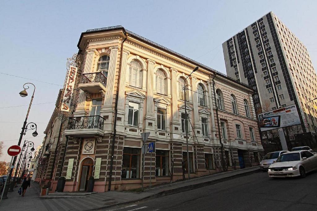 an old building on the corner of a city street at Hotel Versailles in Vladivostok