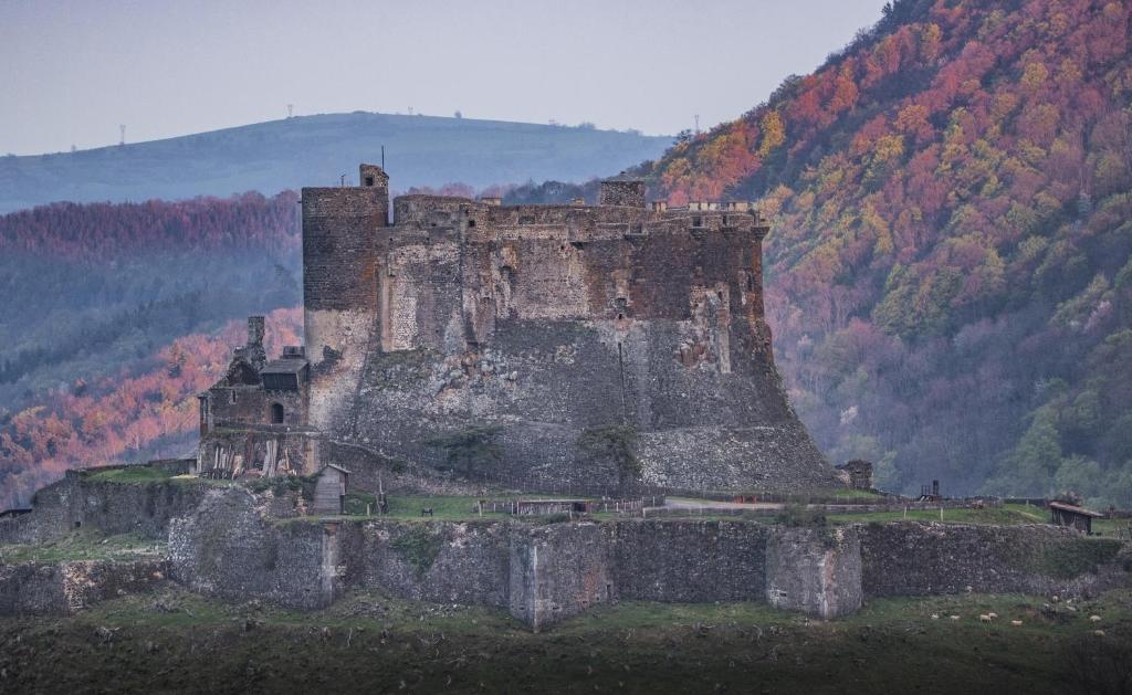 an old castle sitting on top of a hill at Maison de Varennes in Chambon-sur-Lac