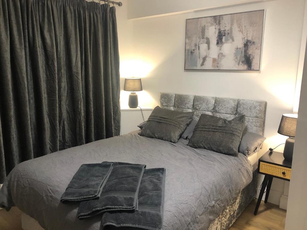 a bedroom with a large bed with a gray blanket at Modern En-suite Double Room in Newport