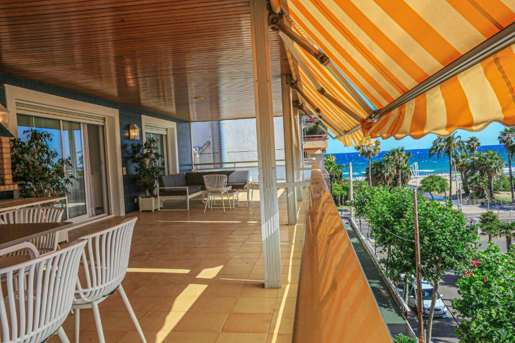 an outdoor patio with chairs and an umbrella at LITORAL COSTA DORADA - AQUARIUM Only families in Cambrils