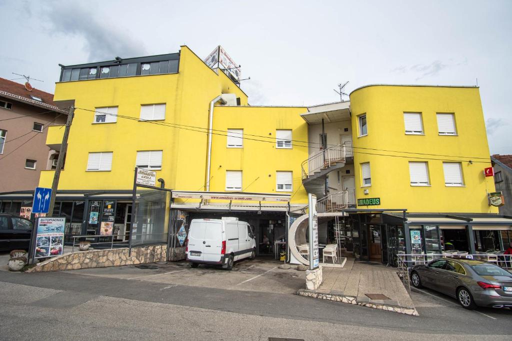 un edificio amarillo con una furgoneta estacionada frente a él en Sobe Amadeus, en Sesvete