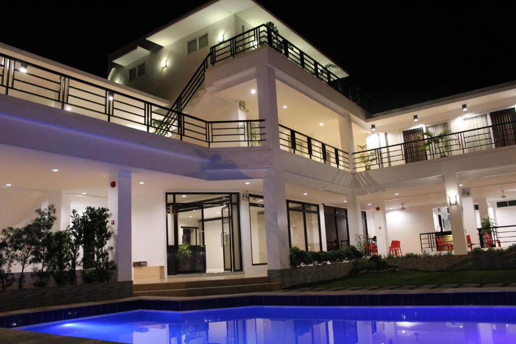 ein großes Haus mit Swimmingpool in der Nacht in der Unterkunft Be-ing Suites in Davao City