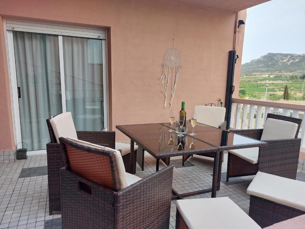 a dining table and chairs on a balcony with a view at Ca la Raquel haus in Corbera