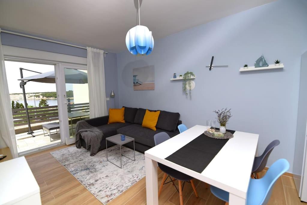 uma sala de estar com um sofá e uma mesa em Apartman Eva em Simuni