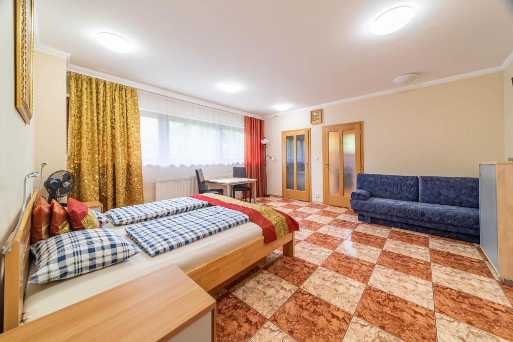 um quarto com uma cama e um sofá azul em Apartmán blizko centra Prahy em Praga