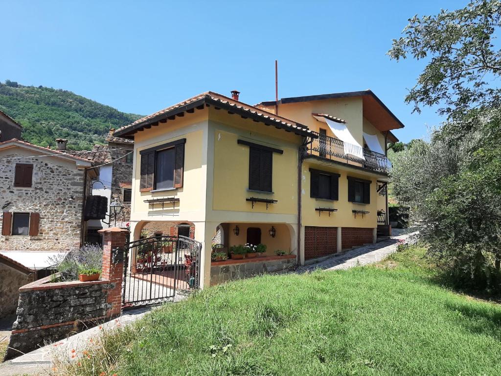 Casa amarilla con balcón en una colina en Case La Sassa, en Marliana