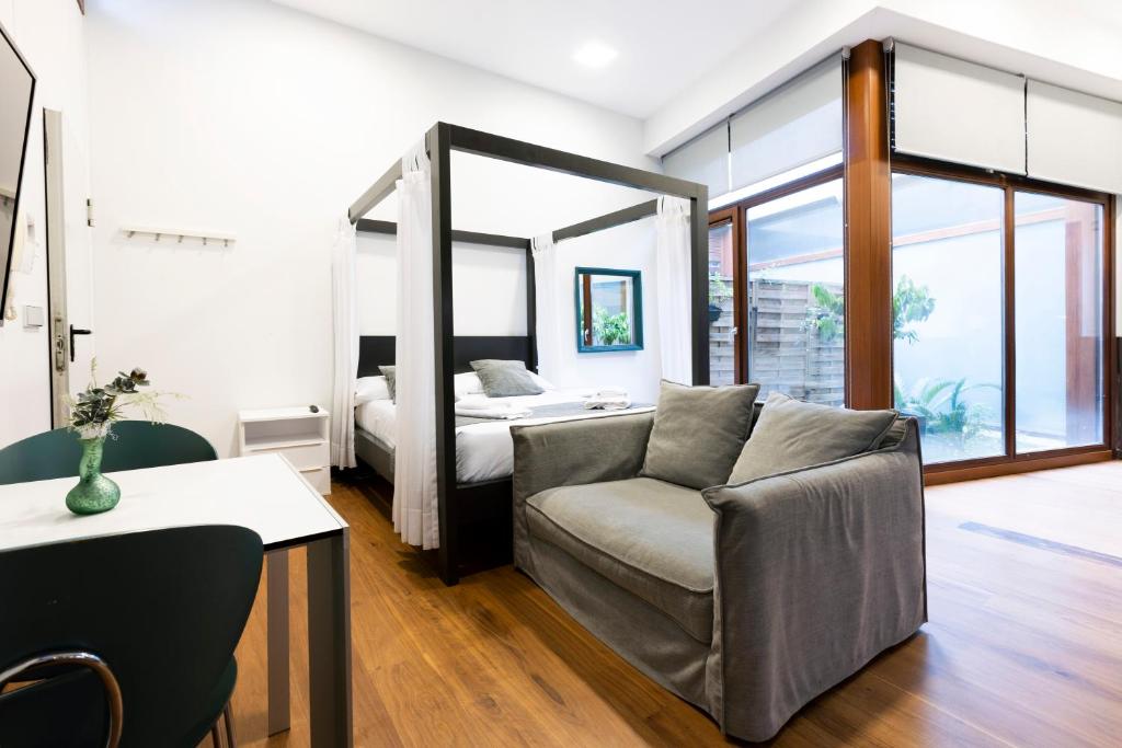 um quarto com uma cama, um sofá e uma cadeira em Loft 2 by Basquelidays em Hondarribia