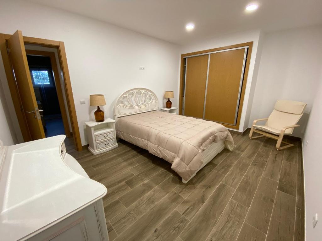 1 dormitorio con cama, escritorio y silla en Casal do Zé, 