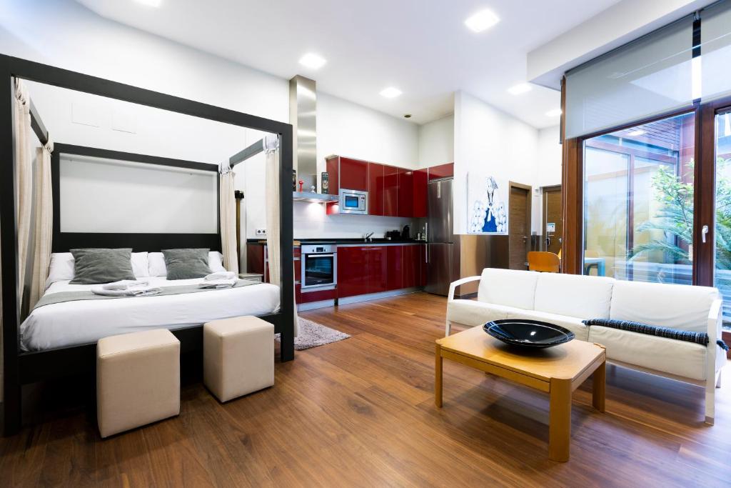 1 dormitorio con cama, sofá y mesa en Loft by Basquelidays, en Hondarribia