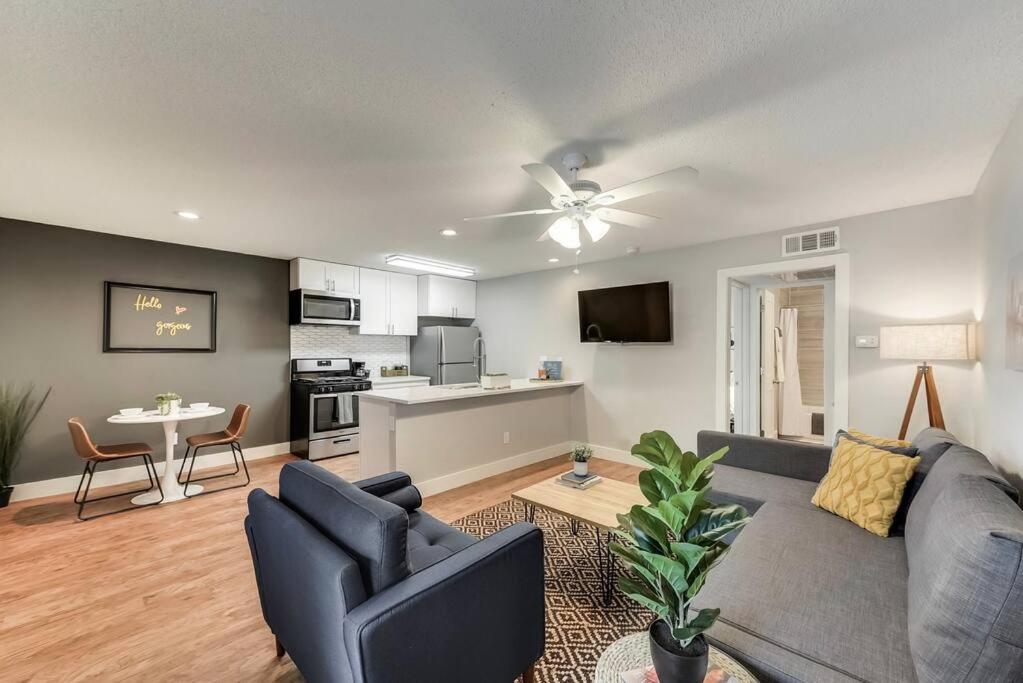 a living room with a blue couch and a kitchen at Hello Gorgeous Flat near Downtown! in Dallas