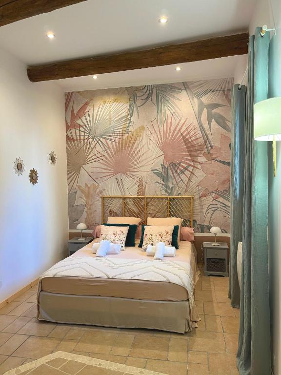 - une chambre avec un grand lit et un mur fleuri dans l'établissement La Source, à Saint-Saturnin-de-Lucian