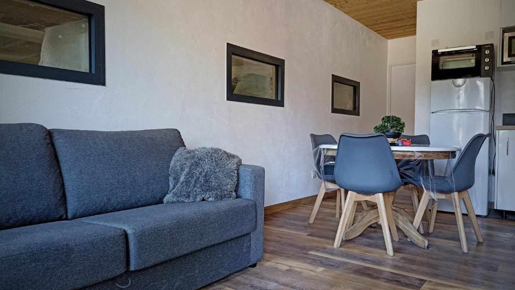ein Wohnzimmer mit einem Sofa und einem Tisch mit Stühlen in der Unterkunft LA GRANGE SAVOYARDE-Spa-Piscine-Proche lac-Charme-Détente- 3 Etoiles in Lathuile