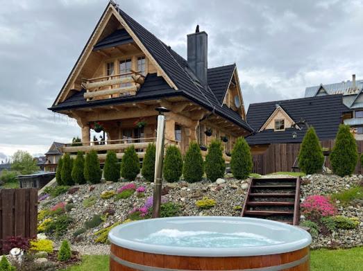 a large house with a hot tub in front of it at Siumno Chatka domki z ruską balią in Murzasichle