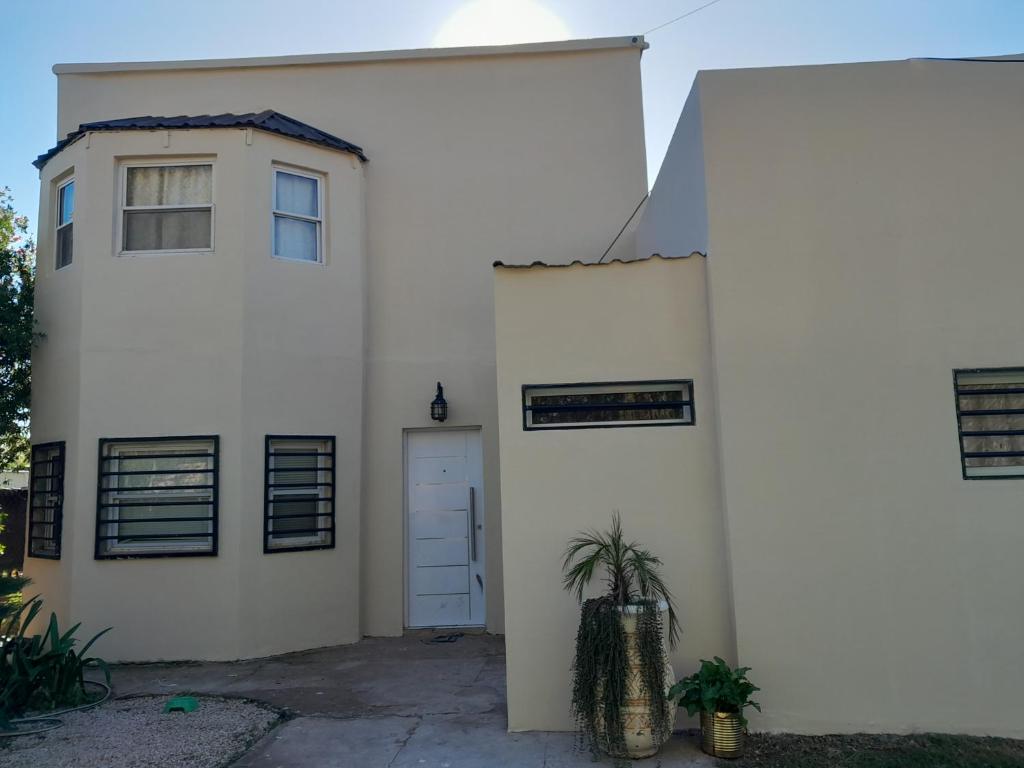 une maison blanche avec une porte et une plante dans l'établissement casa, à San Vicente