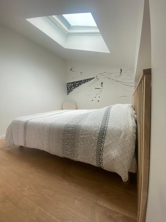 a bedroom with a bed with a skylight at Magnifique grange avec spa / love room in Saint-André-de-Cubzac