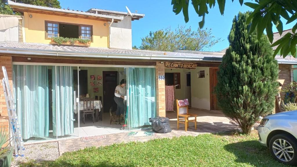 un hombre parado frente a una casa en Casa praia 4 quartos Sul da Ilha Florianópolis, en Florianópolis