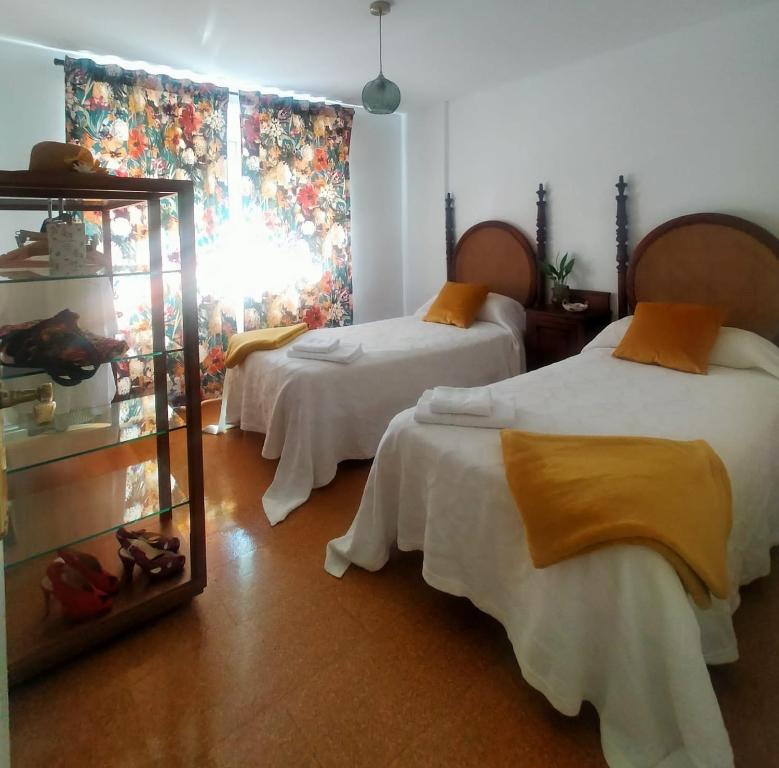 a hotel room with two beds and a window at Cerca de la playa, con bodega, terraza y jardin Camino Portugués in A Guarda