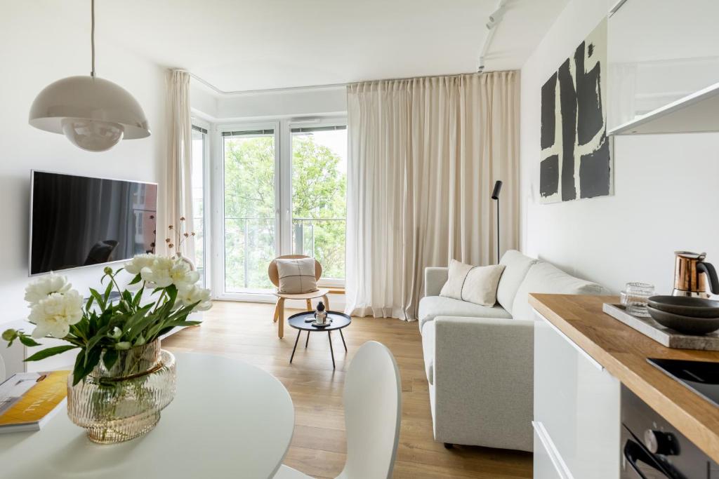 a white living room with a couch and a table at Unique & Modern Apartment Zabłocie in Krakow