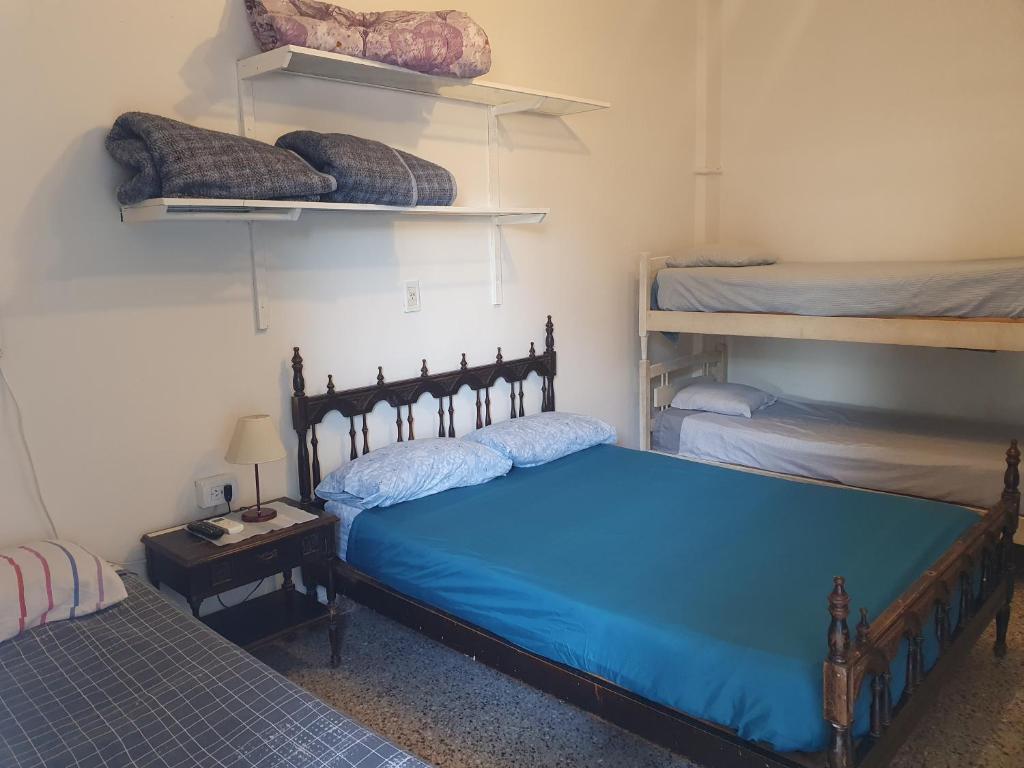 a bedroom with a blue bed and two bunk beds at Hotel Hostal Caballito Blanco in Santa Fe