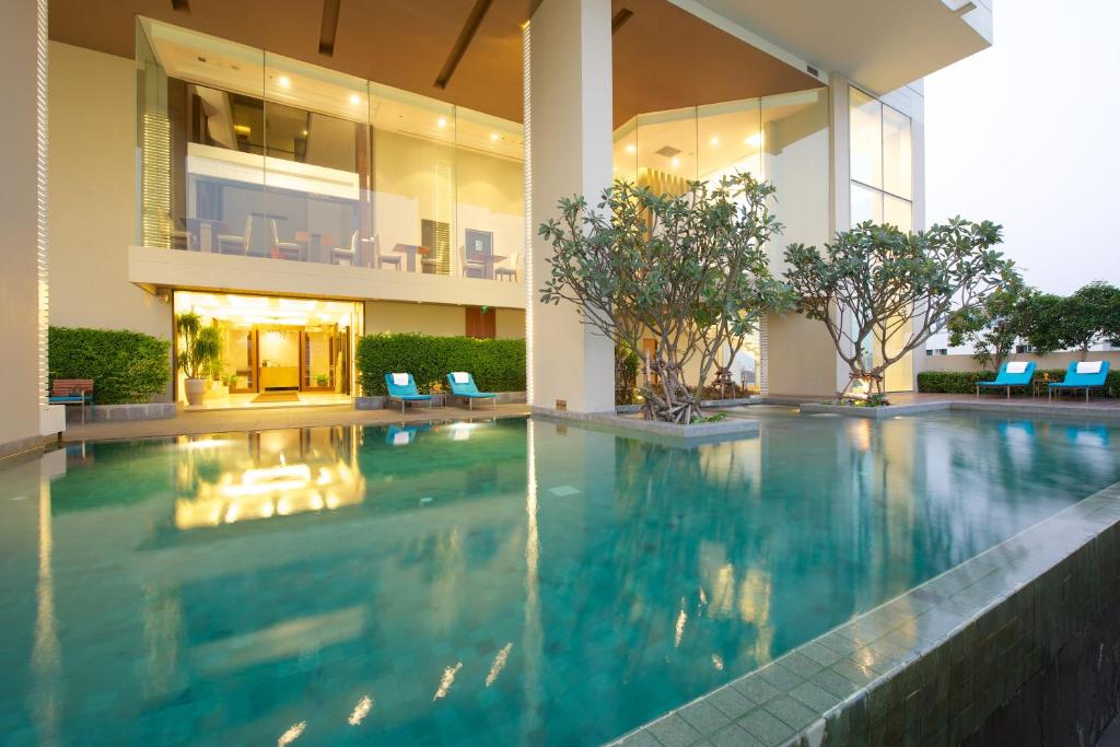 a swimming pool in a building with a house at Jasmine Resort Bangkok in Bangkok