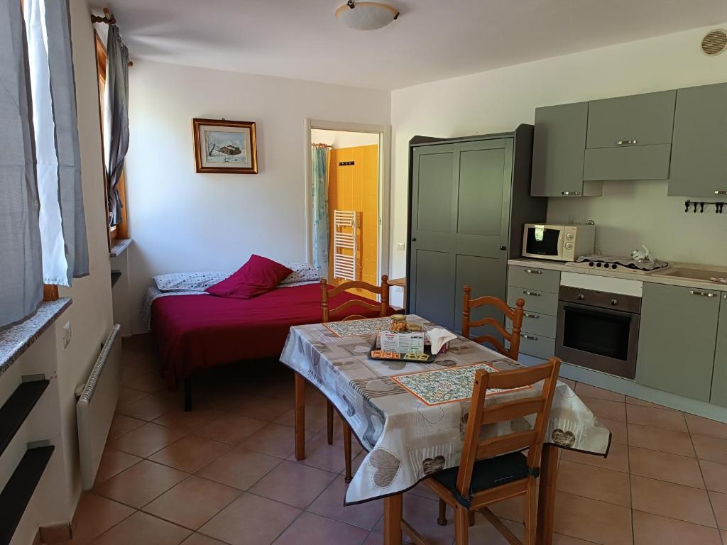 a small kitchen with a table and a room with a bed at Anime Salve B&B HOME RESTAURANT in Sala Baganza
