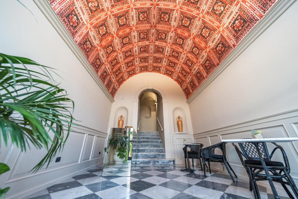 um corredor ornamentado com tecto em caixote e escadas em Palazzo Vergine - by Inside Salento em Gallipoli