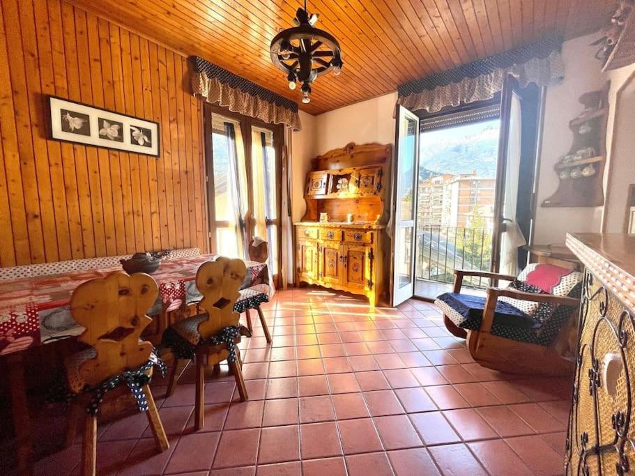 sala de estar con mesa, sillas y ventana en Rustic House Aosta, en Aosta