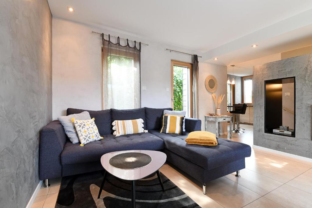 sala de estar con sofá azul y mesa en Gîte Contemporain L'hirondelle, en Guémar