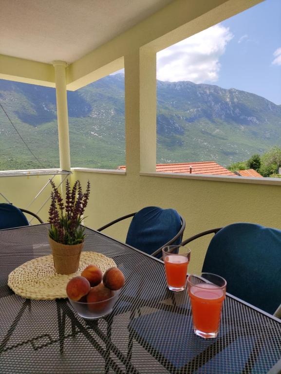una mesa con un bol de fruta y dos vasos de zumo en Mira 1, en Zagvozd