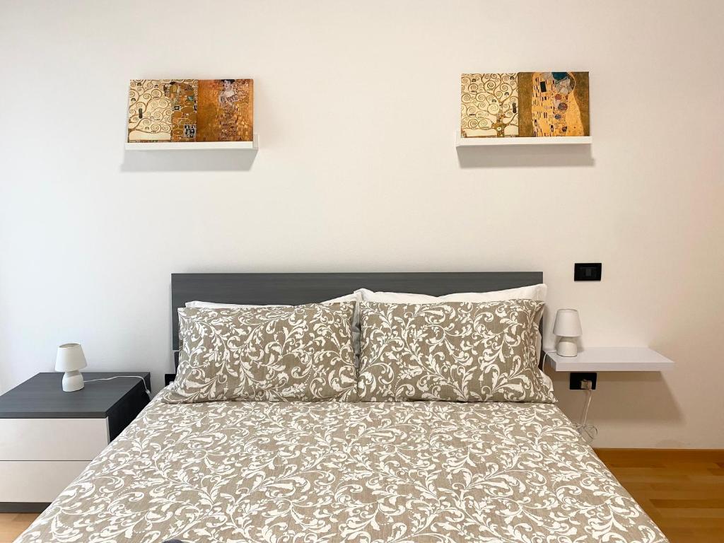 1 dormitorio con 1 cama y 2 cuadros en la pared en Casa Ambra, en Trento