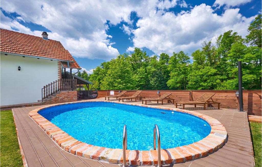 una piscina en una terraza con sillas alrededor en Pet Friendly Home In Hrebinec With Kitchen en Hrebinec