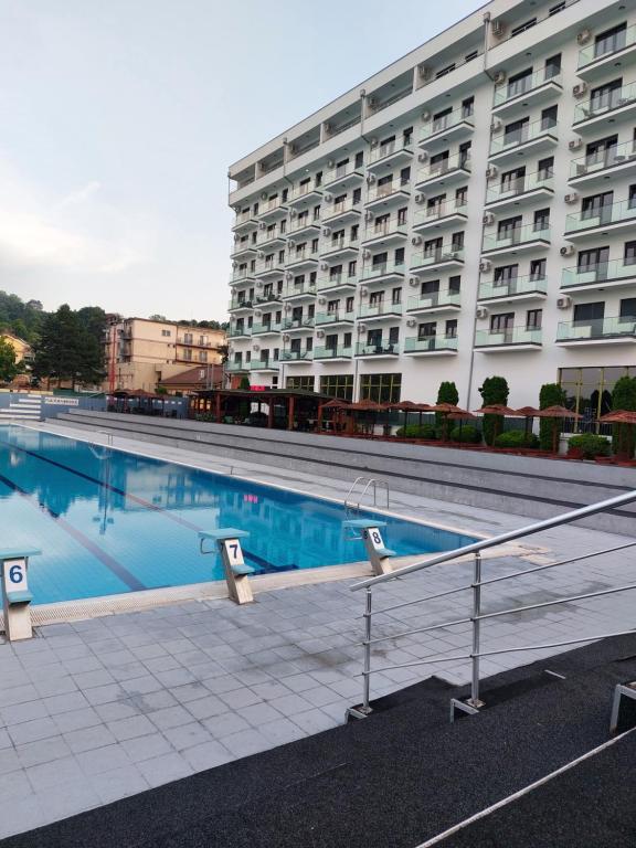 una piscina frente a un gran edificio en JAGODINA apartman, en Jagodina