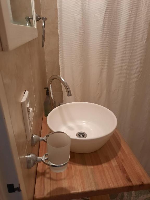 a white sink on a wooden counter in a bathroom at Mar de Anto in Puerto Madryn