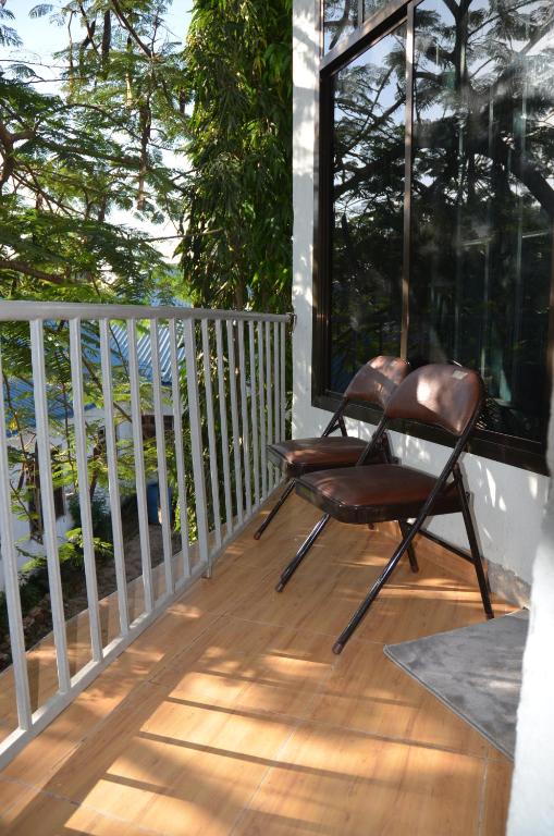 a pair of chairs sitting on a balcony at Elly's Classic Villa in Dar es Salaam